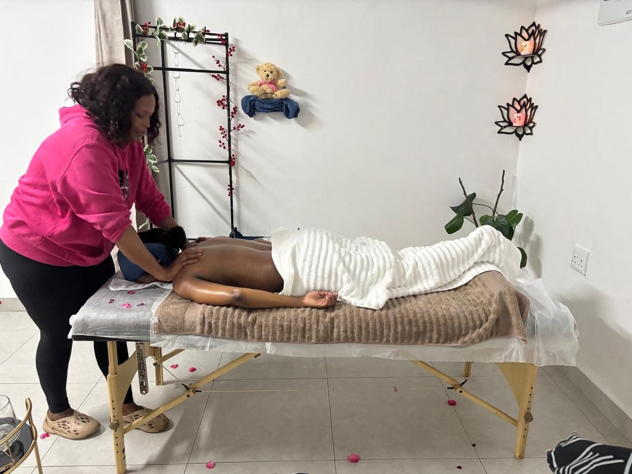 A therapist performing a back massage on a client at Lee Dreams