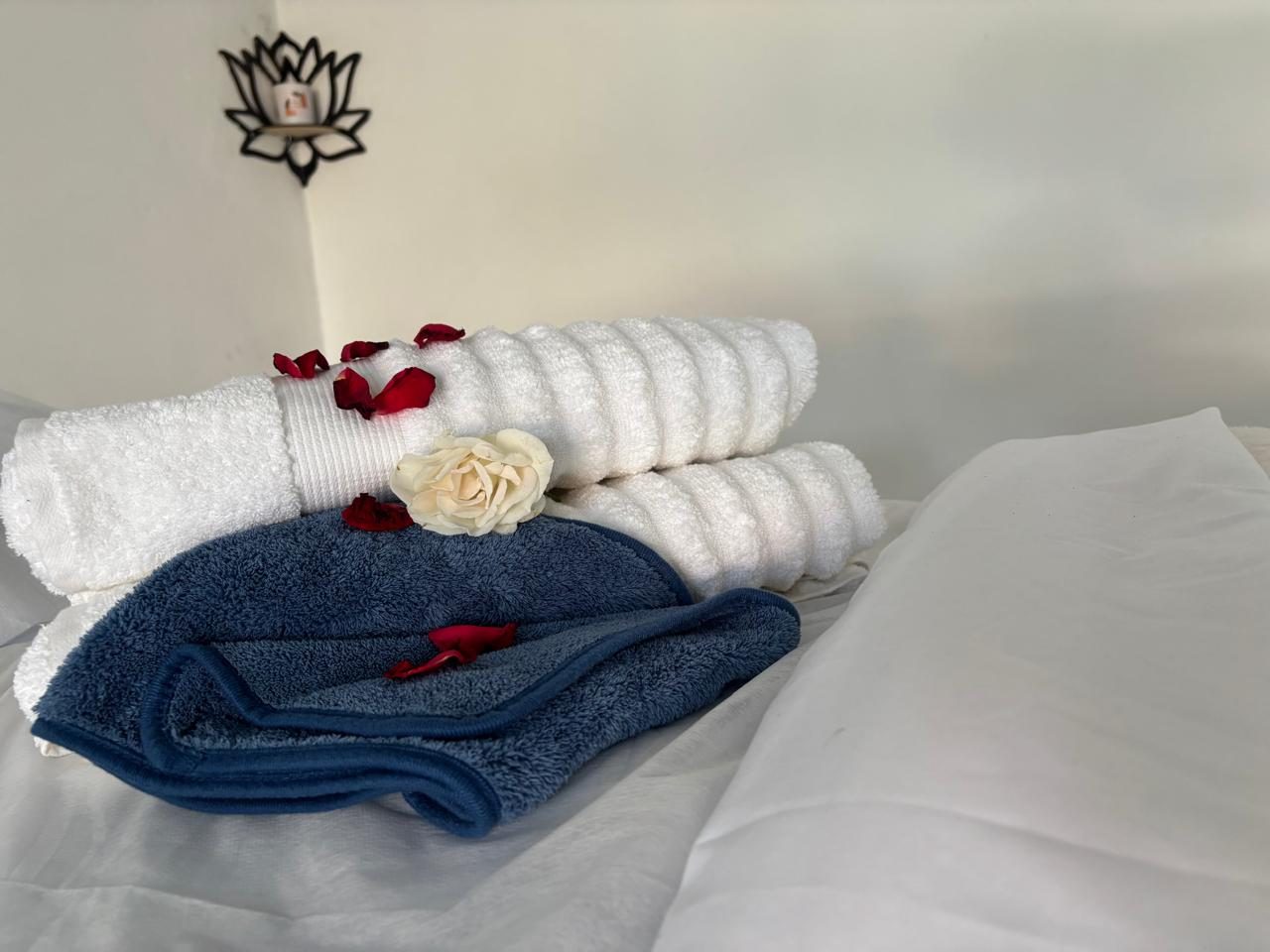 Rolled towels with a single white rose